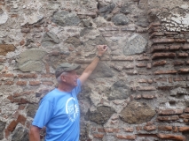 Paul Bosela uses a crack measuring device on a crack in a stone wall in Guatemala